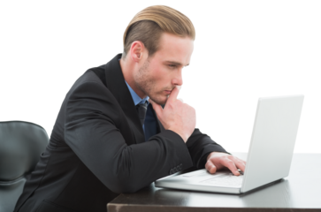 Concentrated businessman using laptop at desk