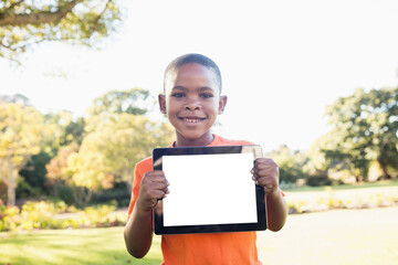 Portrait of boy smiling while holding digital tablet