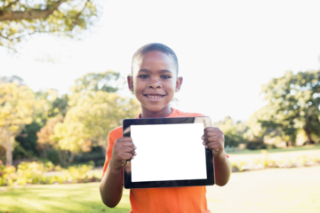 Portrait of boy smiling while holding digital tablet
