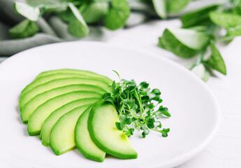 Sliced avocado on white plate