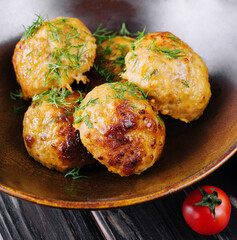 Fried meatballs decorated with salad and tomatoes