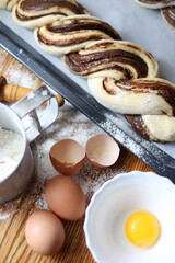braid with chocolate, raw dough for a bun with chocolate. Freshly baked chocolate swirl pastry - babka. Baker make buns from dough with poppy and chocolate filling. Cooking twisted pie. Top view