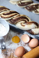 braid with chocolate, raw dough for a bun with chocolate. Freshly baked chocolate swirl pastry - babka. Baker make buns from dough with poppy and chocolate filling. Cooking twisted pie. Top view