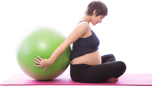 Side view of pregnent woman sitting beside exercise ball