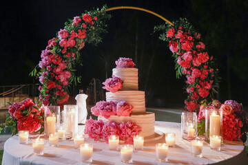 bellissima torta decorata con fiori rosa  per un evento importante in contesto esterno