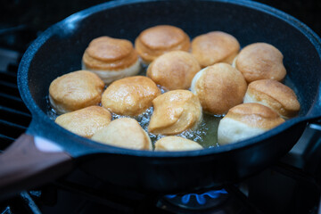 Frying homemade donuts in the kitchen, sweet dessert.