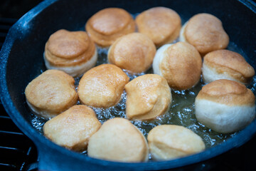 Frying homemade donuts in the kitchen, sweet dessert.