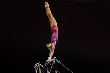 female gymnast performing exercise on uneven bars on black background, sports summer games - obrazy, fototapety, plakaty