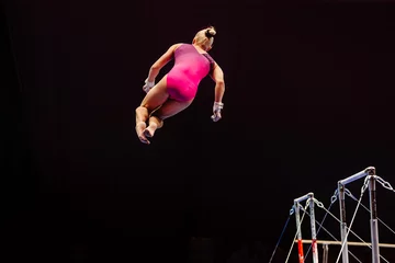 Foto op Plexiglas female gymnast performing somersault gymnastics on uneven bars, black background, sports summer games © sports photos