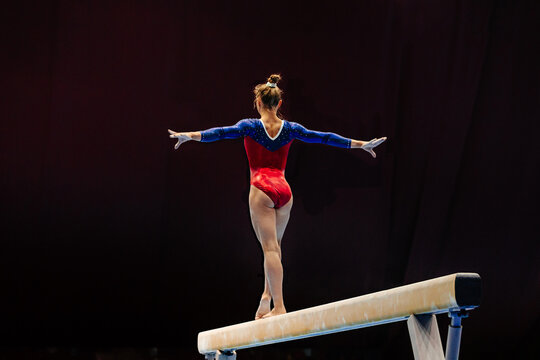 back female gymnast athlete balancing on balance beam gymnastics, sports summer games - Powered by Adobe