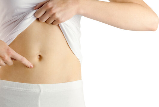 Midsection of slim woman touching her belly