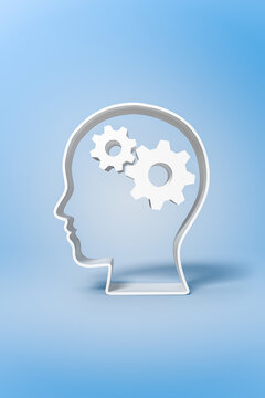 Human head with gears inside on blue backdrop