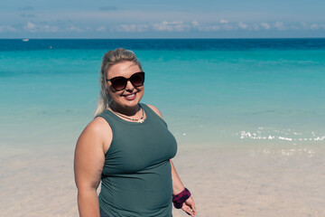 Woman poses for a photo at a tropical beach in Zanzibar, Tanzania along the Indian Ocean