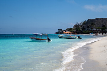 Obraz premium Zanzibar, Tanzania - Boats near the shoreline of the Indian Ocean, near a luxury resort