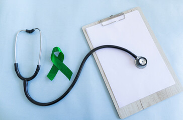 Green awareness ribbon with statoscope and prescription pad 
