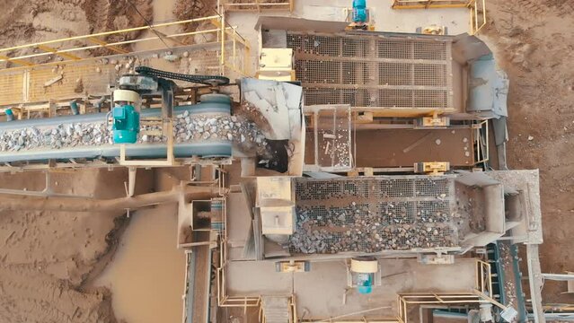 Stones crushing and gravel production on mining quarry. Stone jaw crusher plant. Screening in open-pit mining. Stone crushing plant.