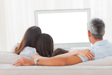 Family watching television together on sofa