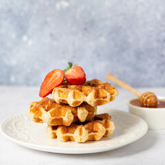 Traditional belgian waffles with fresh fruit and caramel on white background.