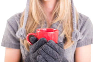 Happy blonde in winter clothes holding mug