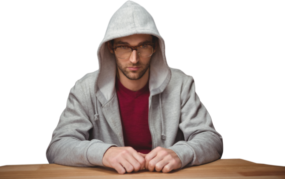 Thoughtful man with hooded shirt sitting at desk - Powered by Adobe