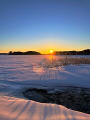 Wintry sunset image on the lake shore.
