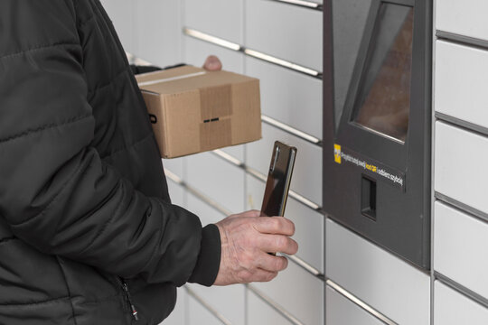 Old man with smartphone entering QR code to open shopping locker. Caption: Read the QR code here and pick it up faster. - Powered by Adobe