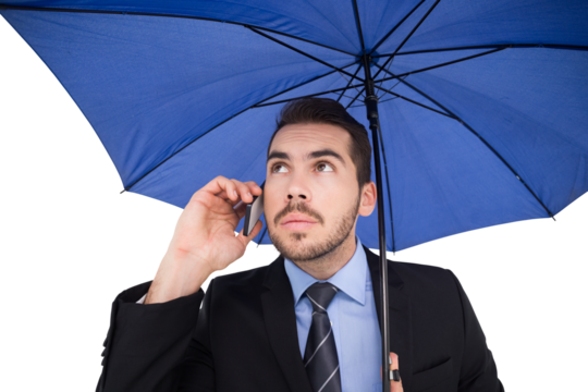 Serious businessman under umbrella phoning - Powered by Adobe