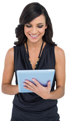 Fototapeta premium Smiling elegant brown haired model typing on tablet