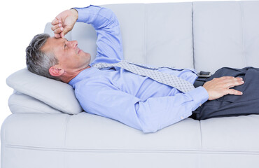 Businessman suffering from headache while lying on sofa