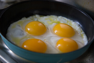 Duck eggs being fried on a metal pan