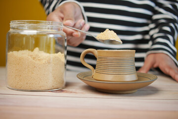 pouring white sugar in a coffee cup ,