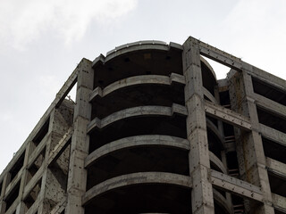 Abandoned ruin of an office complex building. Reinforced concrete structure without any windows and facade elements. Raw building due to a failed construction project.