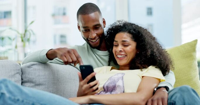 Couple, phone and laughing on sofa in home at comedy, joke or comic meme online. Interracial, cellphone and happiness of black man and woman relax on couch in lounge on social media, funny or humor.