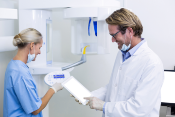 Dentist and dental assistant working on digital tablet