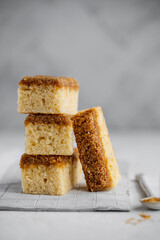 Danish Dream Cake Drømmekage. Sponge cake with coconut and brown sugar topping on a light background.