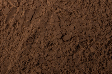 Texture of clay, sand, earth. Brown. Background. Cracked, cracks, waves, mountains, circles, hollows. dented