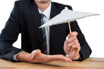 Businessman holding paper umbrella
