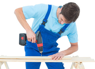 Carpenter using drill machine on wood