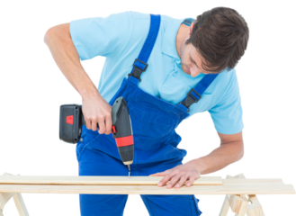 Carpenter using drill machine on wood