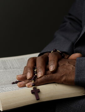 praying to God with hand on the bible on lack background stock photo