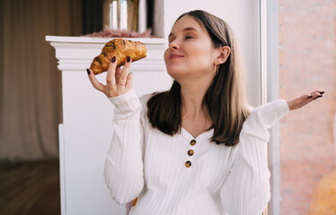 Calm pregnant woman with croissant