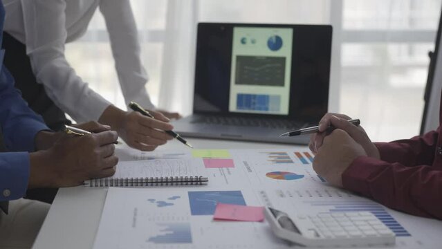 Businessmen summarizing their work in the company during the year new project in the office Young entrepreneurs brainstorm to analyze and plan business strategies.