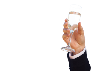 Hand raising champagne glass against clear sky