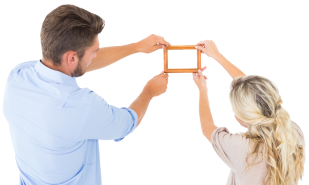 Attractive young couple hanging a frame