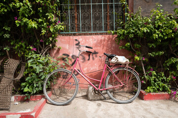 Fototapeta na wymiar un vélo garé le long d'un mur coloré dans la vieille ville de Saint Louis au Sénégal