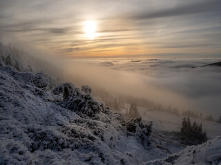 Scenic landscape with a view from a mounatin range to the valley filled with low clouds and fog...