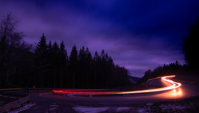Car light lines on a mountain asphalt road in the evening