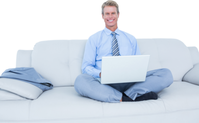 Handsome businessman sitting on sofa using his laptop