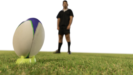 Rugby player preparing to kick the ball on field.