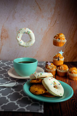 donas y cupcakes con café en una mesa de postres.